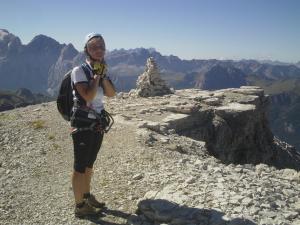 a woman with a backpack standing on top of a mountain at Ciapià in Campitello di Fassa