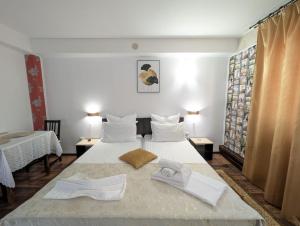 a hotel room with two beds with towels on them at Casa Helen House, Iasi in Valea Adîncă