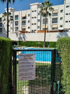 a sign on a gate in front of a swimming pool at Habitación doble con baño privado, Desayuno y piscina in Alboraya +8 photos