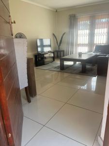 a living room with a table and a couch at Centurion Family House in Centurion