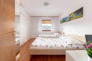 two beds in a small bedroom with a window at Fine Stay Apartments in Žirovnica
