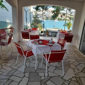 a restaurant with a table and chairs with a view of the water at Pansion Danijela in Rogoznica