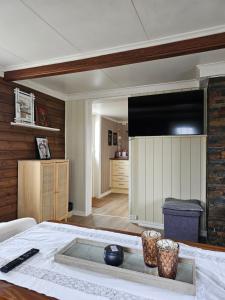 sala de estar con mesa y TV grande en Fishermans Lodge Lofoten, en Hov
