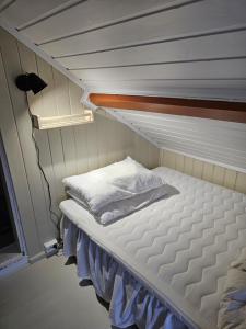 una pequeña habitación con una cama en una habitación pequeña en Fishermans Lodge Lofoten, en Hov