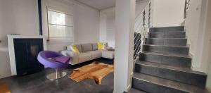 a living room with a couch and a staircase at Casa Vista Mare in Muggia