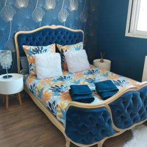 a bedroom with a blue bed with blue walls at chez Sandrine in Miniac-Morvan