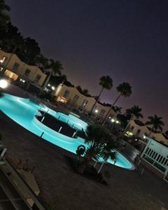 een groot blauw zwembad met palmbomen bij Bungalow Eden Green Oasis in Maspalomas