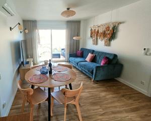 a living room with a table and a blue couch at Sunny La Mata Apartment, Spain in La Mata