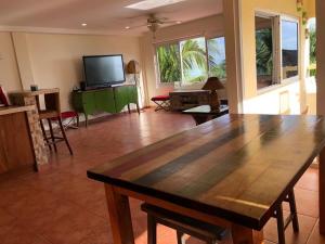 a living room with a large wooden table and a television at En el Mar in Nueva Gorgona