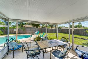 Cozy Home Near Ocean and Daytona Intl Speedway في بورت أورنج: فناء مع طاولة وكراسي بجوار حمام سباحة