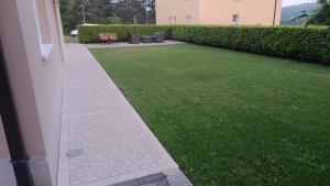 a garden with a lawn and a building at Apartman Iva in Posušje