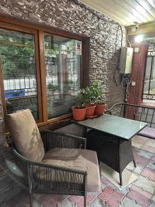 a table and a chair on a patio with plants at Aport hostel Alma-Ata in Almaty