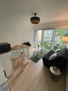 a living room with a couch and a table at Au Cosy Studio II proche Europapark in Erstein
