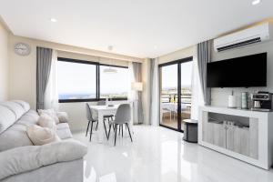 a white living room with a couch and a table at Apartment on the beach Paraiso Playa, Sea Views in Playa Paraiso