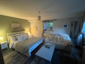 a bedroom with a bed and a couch at Pear Tree Cottage Courtyard in Shrewsbury