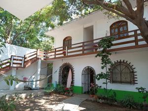 a house with a tree in front of it at Esperanza Casa de Huéspedes in Brisas de Zicatela