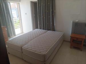 a bed sitting in a room with a window at Athanasia's Apartments in Nerátza