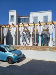 Niebieski samochód zaparkowany przed domem w obiekcie Κυκλαδίτικη βίλα στην Παραλία Αντώνηδες, Κύθνου w mieście Kitnos