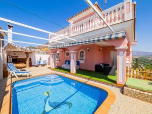 a villa with a swimming pool in front of a house at Villa Ana Todo Confort in Alora