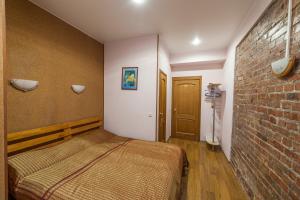 a bedroom with a bed and a brick wall at Canny House in Saint Petersburg