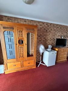 a room with a wooden cabinet and a television at San Michele Adaminaby in Adaminaby