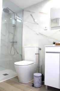 a white bathroom with a toilet and a shower at 1000Jo Apartment T2 in Gulpilhares