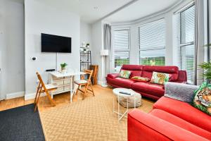 a living room with a red couch and a table at West Beach 3 - Portrush by the Sea in Portrush