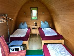 a room with two beds and a table and a window at Glampingpod in Loitz