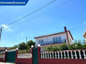 a red fence in front of a house at W.H.House in Atouguia da Baleia