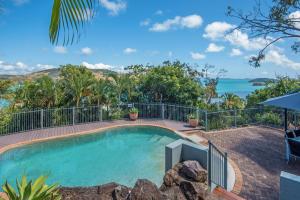 a swimming pool with a view of the ocean at Heliconia Grove - 3 bedroom - on Hamilton Island by HIHA in Hamilton Island