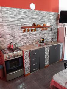 a kitchen with a stove and a sink at Los cuca in Santa Teresita