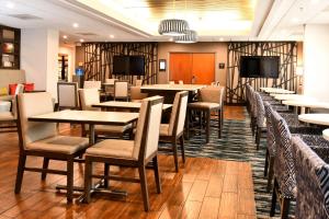 a dining room with tables and chairs and televisions at Hampton Inn Santee-I-95 in Santee