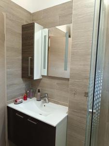 een badkamer met een wastafel en een spiegel bij Apartment Nada in Rogoznica