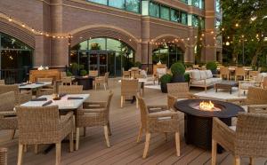 a restaurant with tables and chairs and a fire pit at Hilton Atlanta Northeast in Norcross
