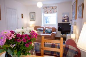a living room with a vase of flowers on a table at 26 Rosemary Lane in Beaumaris