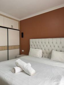 a white bed with two rolled towels on it at Bella Vista at Enzi Heights along Mombasa Rd next to Nextgen close to JKIA in Nairobi