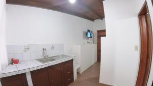 基多Hotel Suite Central Park Tababela的带水槽和台面的厨房