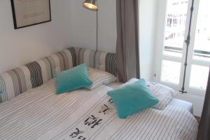 a bed with two blue pillows on top of it at Appartement Résidence Astoria in Chamonix