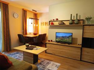 salon z telewizorem w drewnianym centrum rozrywki w obiekcie Appartement Schneeglöckchen w mieście Bad Gastein