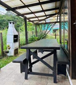 a picnic table under a pergola with a grill at Casa Albatroz do Rosa - Albatroz Hospedaria in Imbituba