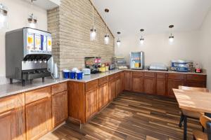 a kitchen with wooden cabinets and a counter top at Days Inn by Wyndham Wauseon in Wauseon
