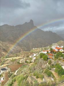 a rainbow over a village with a mountain at Casa La Parra in Tejeda