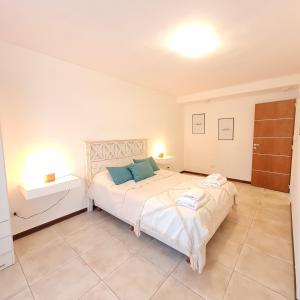 une chambre avec un grand lit blanc avec des oreillers bleus dans l'établissement Morenito - Andarlibre, à San Martín de los Andes