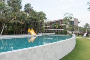 a swimming pool with a slide in front of a building at Fisherman's Resort Haad Chao Samran in Haad Chao Samran