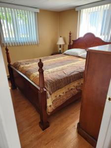 a bedroom with a large bed with a wooden floor at Appartement de la rive 2 in Shippagan
