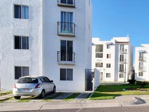 ein Auto, das vor einem weißen Gebäude parkt in der Unterkunft Hacienda de Cortés in Tlacote el Bajo