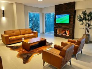 een woonkamer met een bank en een open haard bij Luxuoso Studio no Serra Class (307) in Canela