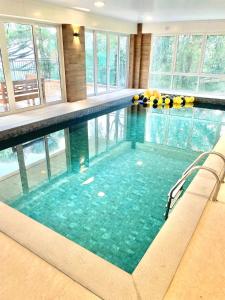 een groot zwembad in een gebouw met glazen ramen bij Luxuoso Studio no Serra Class (307) in Canela