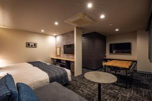 a hotel room with a bed and a table and a couch at Hotel Quest Shimizu in Shizuoka