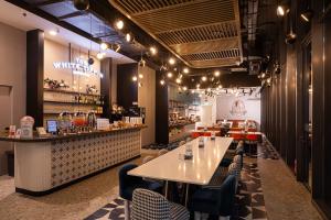 a restaurant with a table and chairs and a bar at Hotel Faber Park Singapore - Handwritten Collection in Singapore